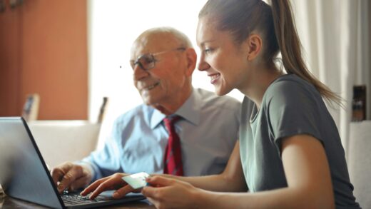 Starszy mężczyzna i młoda kobieta używają laptopa